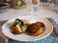 Två gyllenbruna biffar, troligen baserade på ett linser recept, serveras med en fräsch sallad och en klick sås.