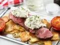 Saftig oxfilé Provencale med krämig topping, serverad med krispiga potatisskivor och grillade tomater. En festmåltid!