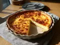 En gyllene ostpaj med en skiva borttagen, perfekt för ett enkelt ostpaj recept.