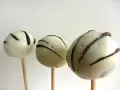 Tre vita cake pops med mörk chokladglasyr, perfekta för ett enkelt cake pops recept.