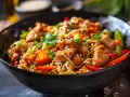 En läcker kycklingwok med nudlar och grönsaker, toppad med sesamfrön och färsk koriander. En perfekt måltid för en snabb och smakrik middag.