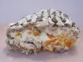 En bit av en Budapestrulle med aprikoser och grädde, toppad med choklad och florsocker. Ett härligt budapestrulle recept!