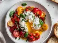 En krämig burrata med färgglada tomater och färsk basilika, en perfekt sommarrätt.