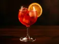 Ett glas Campari Spritz med is och apelsinskiva, perfekt för en solig eftermiddag.