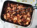 Saftigt, dras isär fläskkött i en ugnsform, redo att serveras. Ett perfekt carnitas recept för en festmåltid.