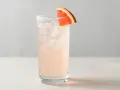 En uppfriskande Paloma drink med is och en grapefruktskiva som garnering.