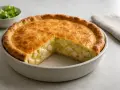 En gyllene kycklingpaj med en bit borttagen, som visar saftig kyckling och potatis. Ett perfekt kycklingpaj recept för middagen.