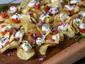 Krispiga chips med klickar av smetana, röd rom, finhackad rödlök och gräslök. En festlig förrätt!