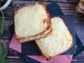 Två gyllene croque monsieur-smörgåsar med smält ost och skinka, serverade på en rutig duk.