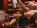 En bartender häller upp en Pornstar Martini i ett elegant glas.