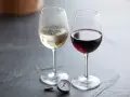 Två glas vin, ett vitt och ett rött, med en termometer bredvid. Perfekt vitt vin temperatur är viktigt för njutning.