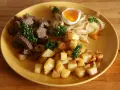 En tallrik med stekt kött, stekt potatis, stekt lök och ett kokt ägg. Ett klassiskt husmanskost recept som passar perfekt för en vardagsmiddag.