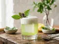 En uppfriskande thai basil drink med skummig topp, garnerad med färska basilikablad. En perfekt sommardrink.