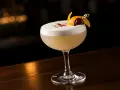 En perfekt vodka sour med fluffigt skum, garnerad med apelsinskal och körsbär.