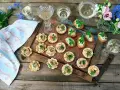 Små, läckra snacks till bubbel, serverade på ett fat med blommor och glas. Perfekt för en festlig stund.
