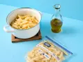 Koka pasta och förbered för att frysa in den. En kastrull med penne, en flaska olivolja och en fryspåse syns.