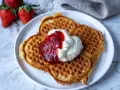 Gyllene belgiska våfflor med vispad grädde och jordgubbssylt. Ett perfekt recept för en lyxig frukost eller fika.