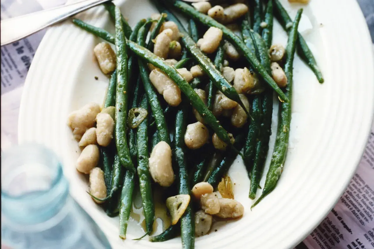 En tallrik med gröna haricots verts och vita bönor, lätt oljade och kryddade. En läcker och enkel rätt.