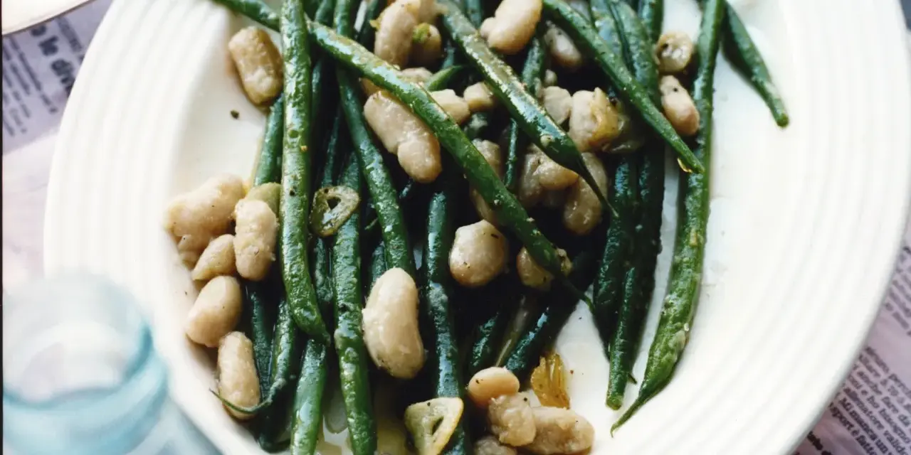 En tallrik med gröna haricots verts och vita bönor, lätt oljade och kryddade. En läcker och enkel rätt.