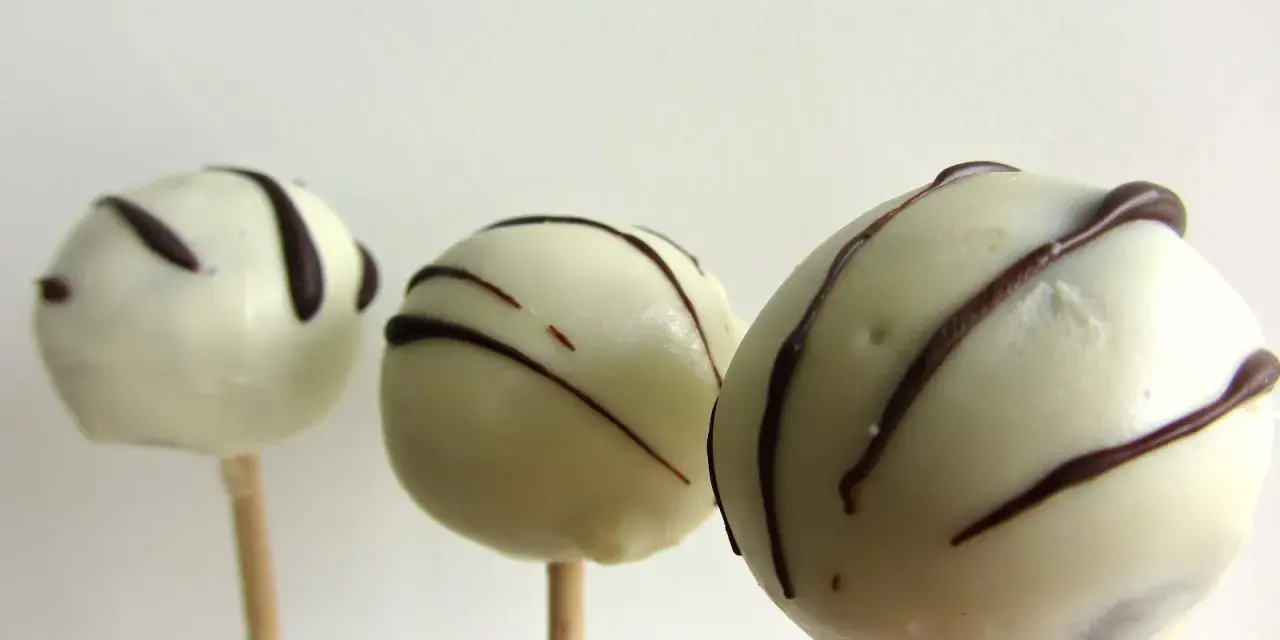 Tre vita cake pops med mörk chokladglasyr, perfekta för ett enkelt cake pops recept.