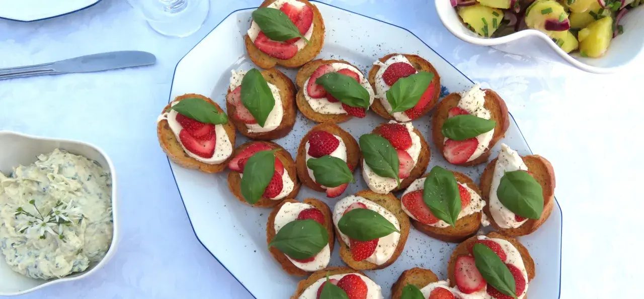 Bruschetta med mozzarella, jordgubbar och basilika. En härlig sommardelikatess som passar perfekt till mingel.