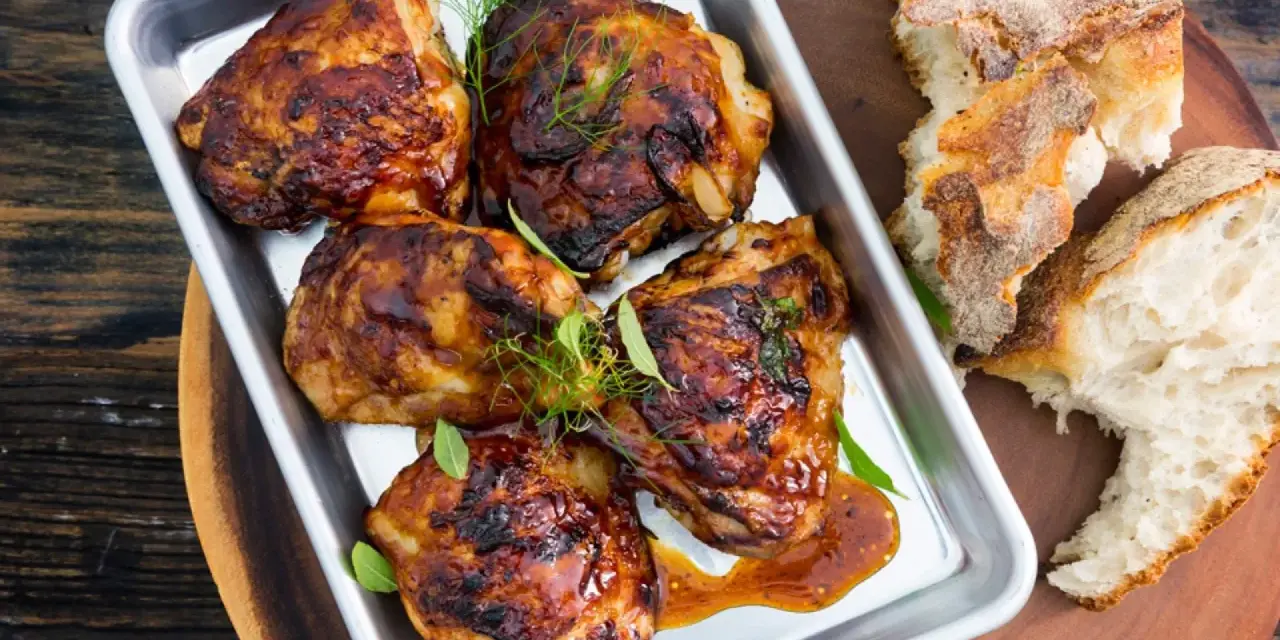 Saftiga kycklinglår med ben, glaserade och serverade med bröd. Ett perfekt kycklinglår med ben recept för middagen.