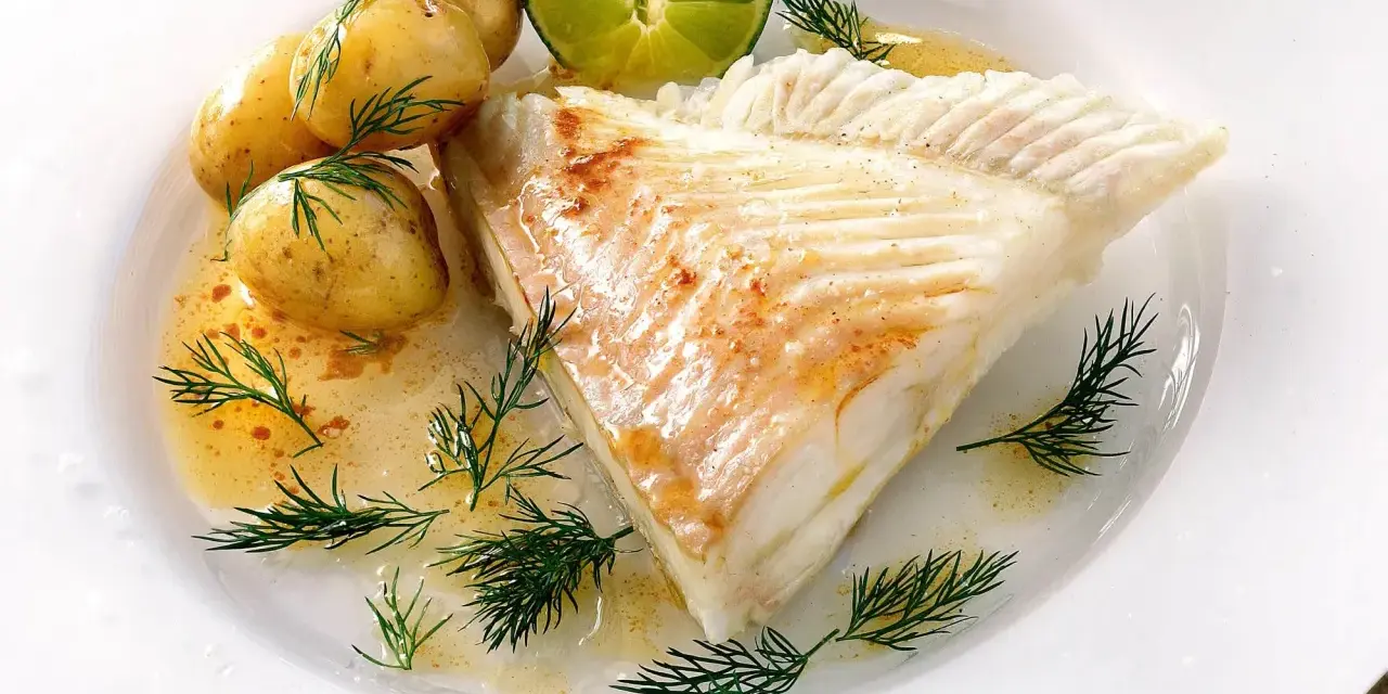 Piggvar i ugn serverad med småpotatis, dill och en limeklyfta. En delikat rätt som doftar hav.