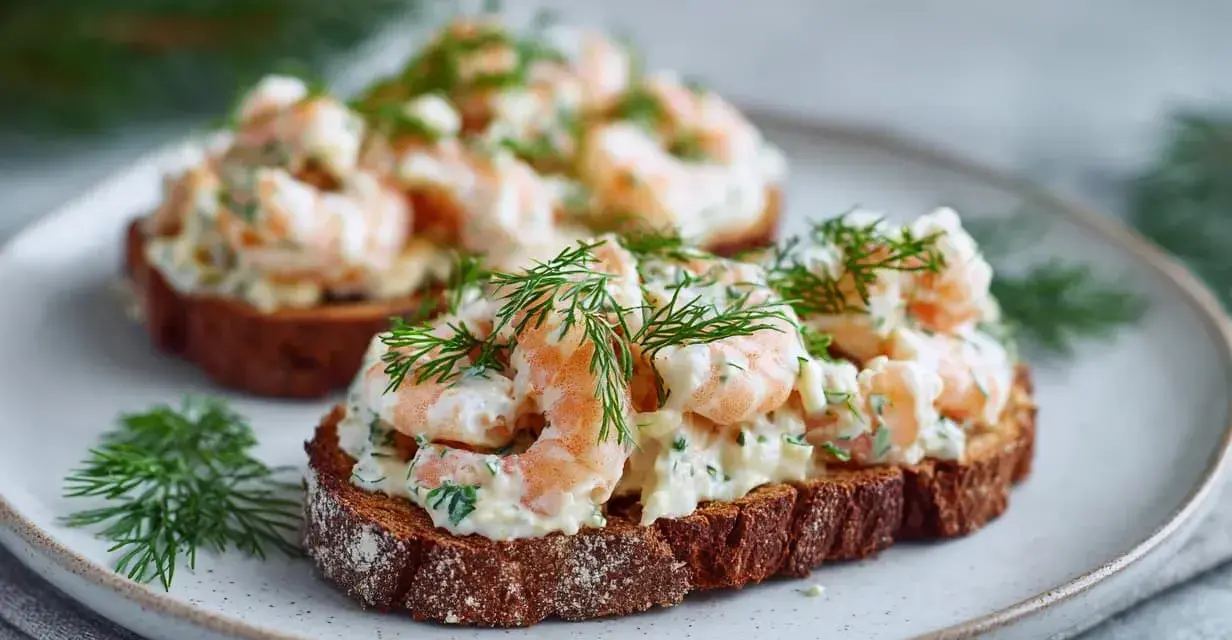 Två läckra skagen toast med räkor och dill på mörkt bröd, serverade på en tallrik.