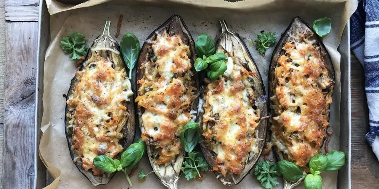 Fyra halverade auberginer fyllda med pasta och ost, ett läckert aubergine recept. Garnerade med färska örter.