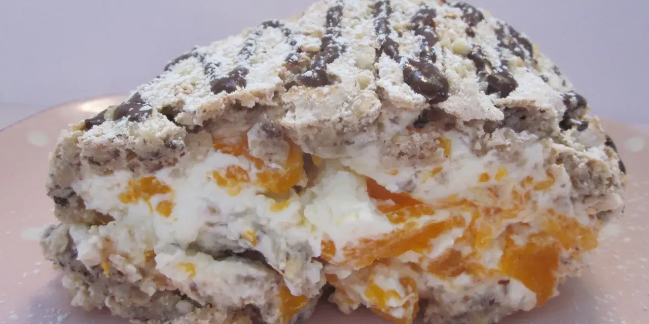 En bit av en Budapestrulle med aprikoser och grädde, toppad med choklad och florsocker. Ett härligt budapestrulle recept!