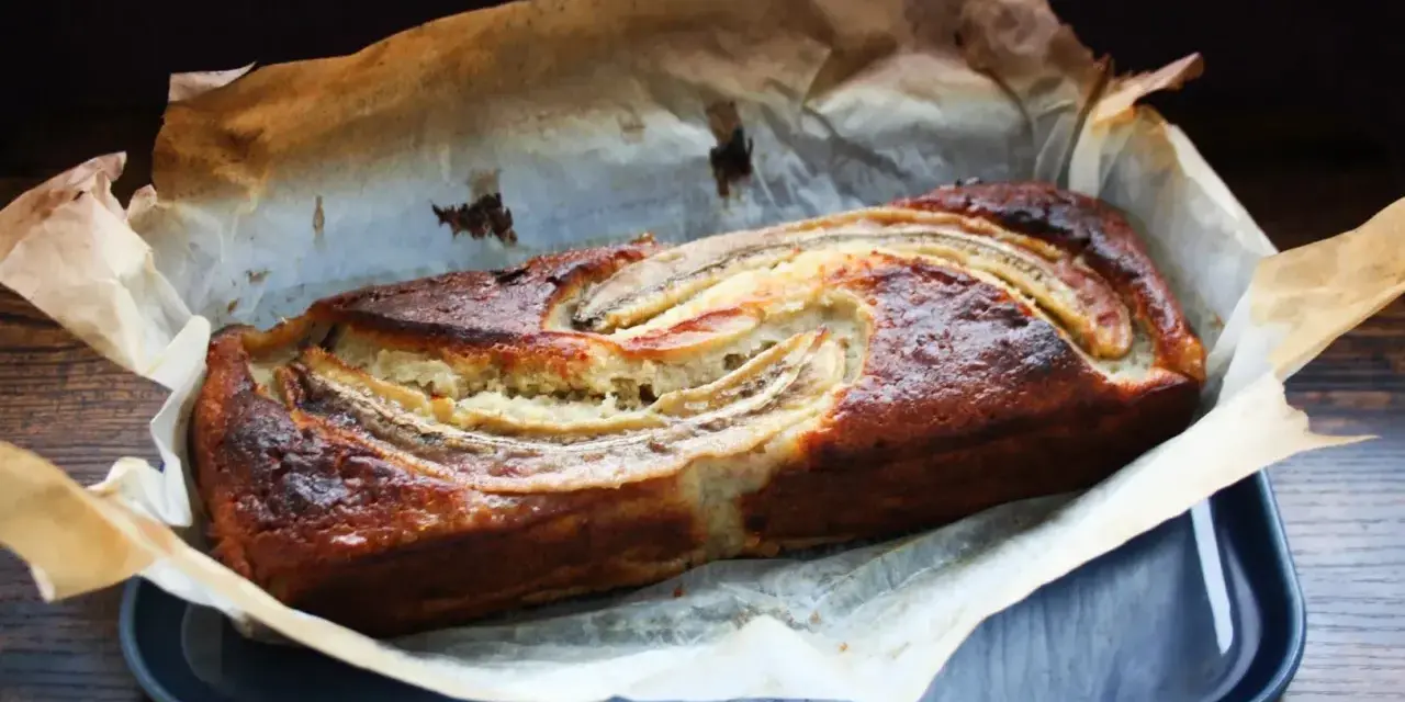 Nybakad banankaka med gyllene skorpa och bananskivor på toppen. Perfekt att baka med banan!