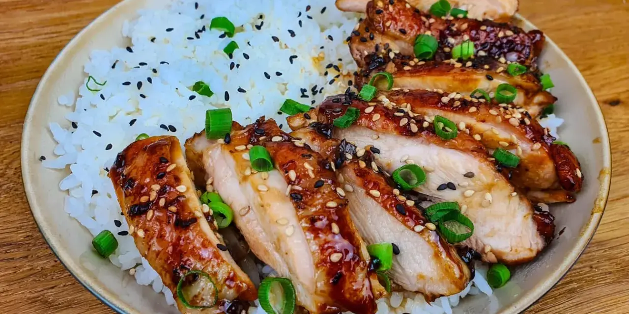 Skivad kyckling i gochujang marinad, serverad med ris och toppad med sesamfrön och salladslök. En härlig rätt som lockar smaklökarna.