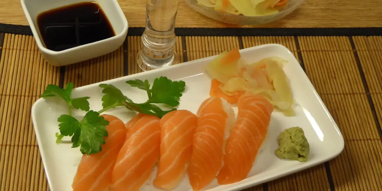 Njut av grillad lax sushi med wasabi, ingefära, sojasås och en shot sake.