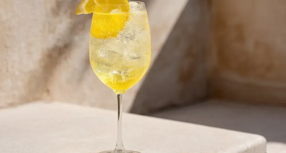 Ett glas med is och en citronskiva, fyllt med en bubblig limoncello spritz.
