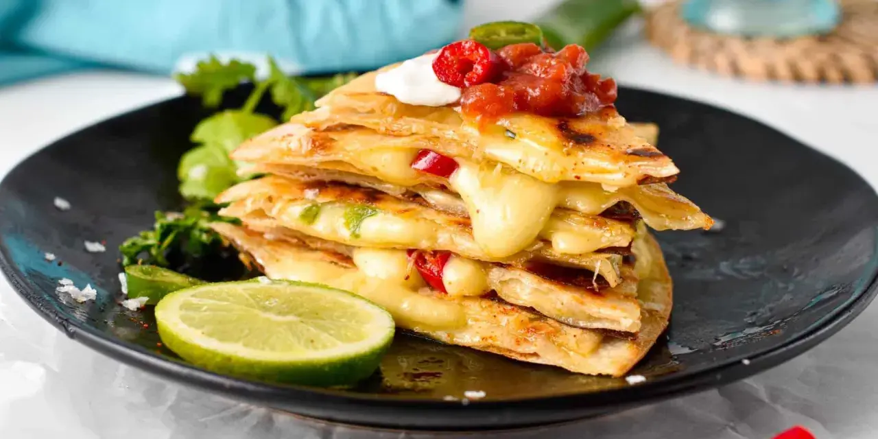 En stapel krispiga quesadillas med smält ost, jalapeños och salsa. Ett perfekt monterey jack ost alternativ för en smakrik måltid.