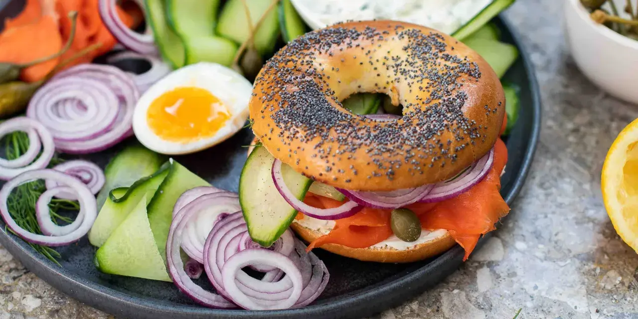 En bagel med lax, färskost, rödlök, gurka och kapris. Ett perfekt brunch recept för en lyxig start på dagen.