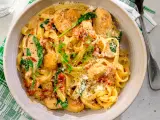 En krämig pastarätt med kyckling och soltorkade tomater, toppad med parmesan och färska örter.