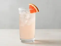 En uppfriskande Paloma drink med is och en grapefruktskiva som garnering.