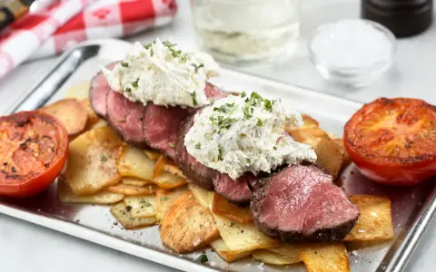 Saftig oxfilé Provencale med krämig topping, serverad med krispiga potatisskivor och grillade tomater. En festmåltid!