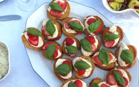 Bruschetta med mozzarella, jordgubbar och basilika. En härlig sommardelikatess som passar perfekt till mingel.