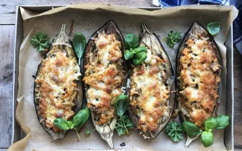 Fyra halverade auberginer fyllda med pasta och ost, ett läckert aubergine recept. Garnerade med färska örter.