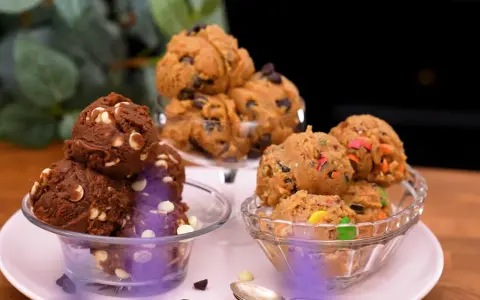 Tre skålar med härlig cookie dough paj: en med choklad och vita chokladknappar, en med chokladknappar och en med färgglada godisbitar.