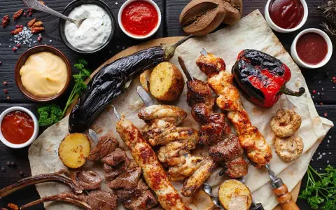 En härlig grilltallrik med köttspett, kycklingvingar, grönsaker och såser. Perfekt vin till tagliata.
