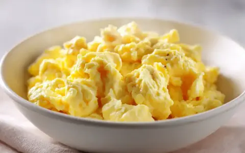 En skål med fluffiga, gyllene äggröror, perfekt för ett enkelt scrambled eggs recept.