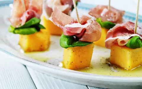 Små spett med saftig melon och salt skinka, toppade med färsk basilika. En klassisk och läcker kombination av melon och skinka.