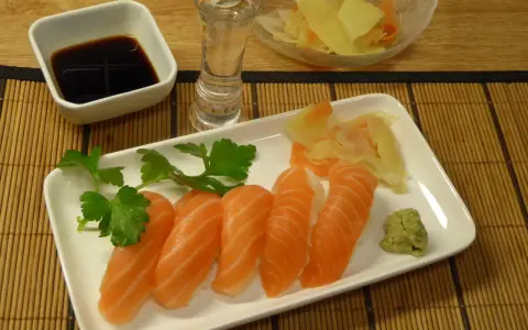 Njut av grillad lax sushi med wasabi, ingefära, sojasås och en shot sake.