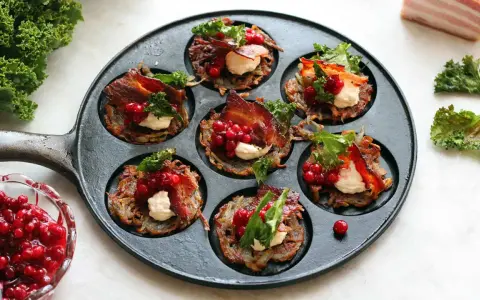 Små rårakor med bacon, gräddfil och lingon i en gjutjärnspanna. Ett härligt recept på rårakor!