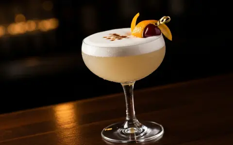 En perfekt vodka sour med fluffigt skum, garnerad med apelsinskal och körsbär.