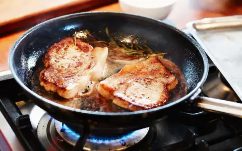 Två saftiga fläskkotletter steks i en panna med rosmarin. Ett perfekt karre recept för en god middag.