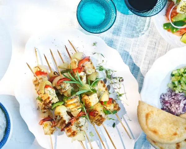 Grillade spett med souvlaki kyckling, grönsaker och örter. Serveras med tzatziki, sallad och pitabröd.